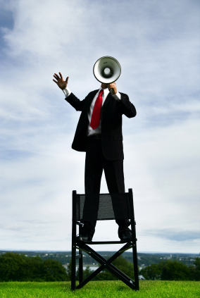 Mand på stol med megafon